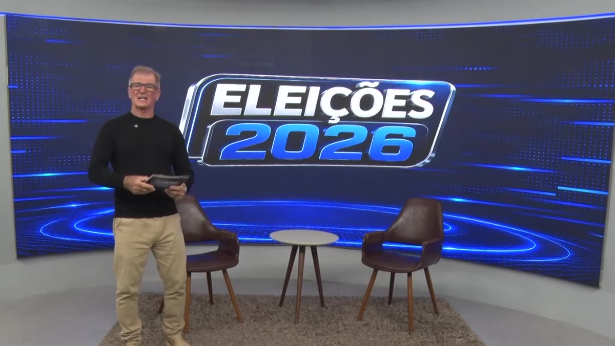 Estúdio da série Eleições 2026, com duas poltronas e o apresentador em pé