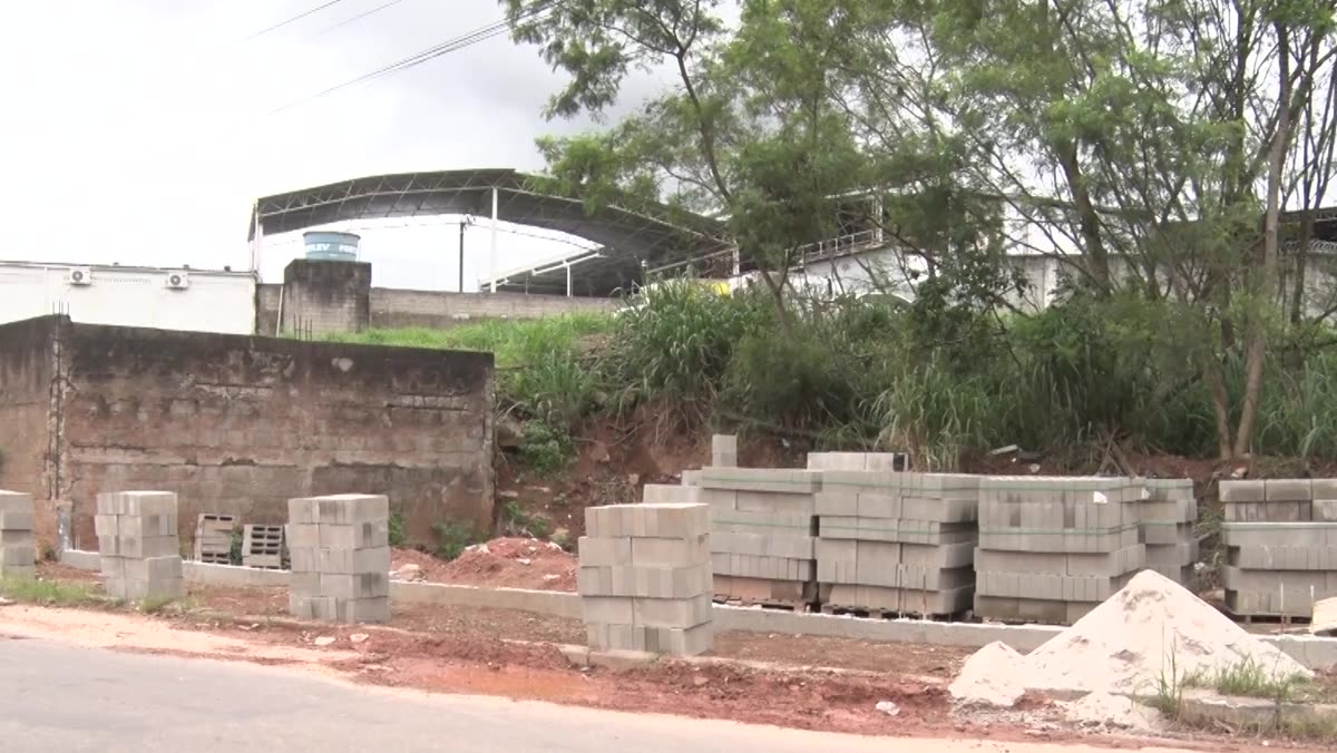 Muro de blocos em construção ao lado da calçada de uma rua em Muquiçaba