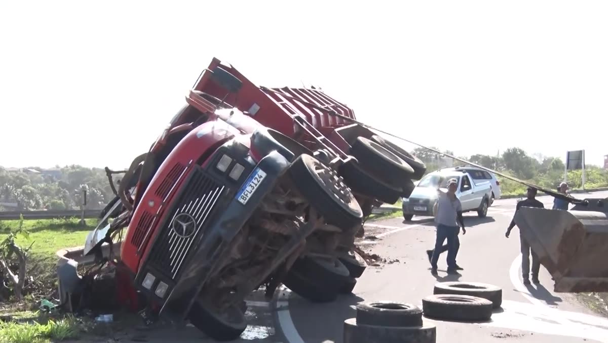 Caminhão caçamba tombado na pista do trevo de Meaípe, com pneus no asfalto