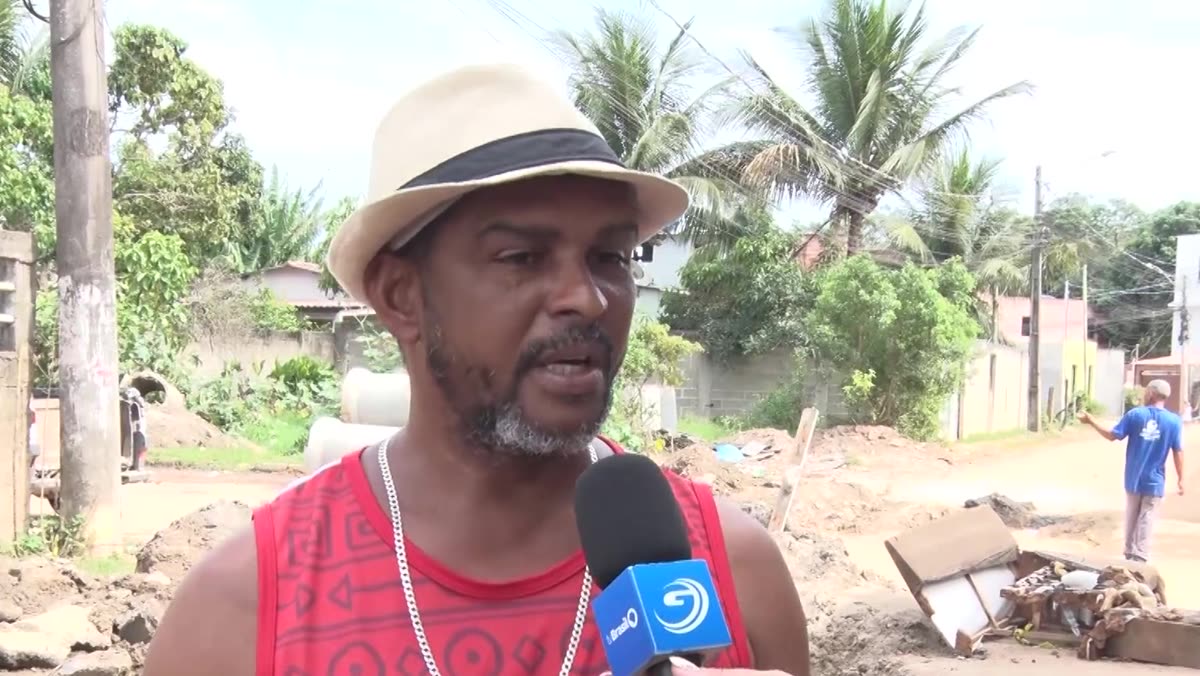 Morador de chapéu fala à reportagem, com a obra ao fundo