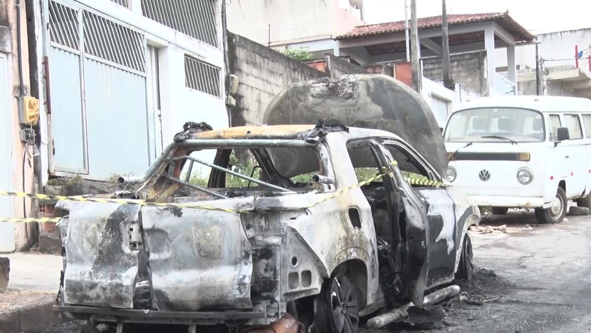Carcaça queimada de um carro na rua