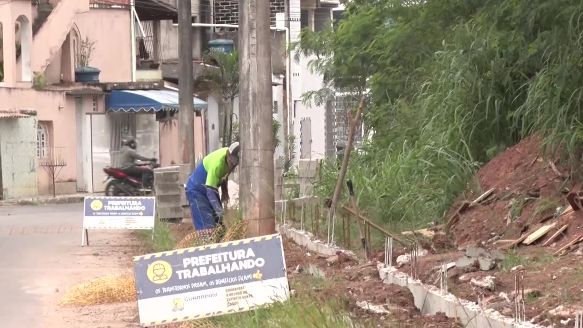 Faixa estreita de calçada entre o muro em construção e a rua