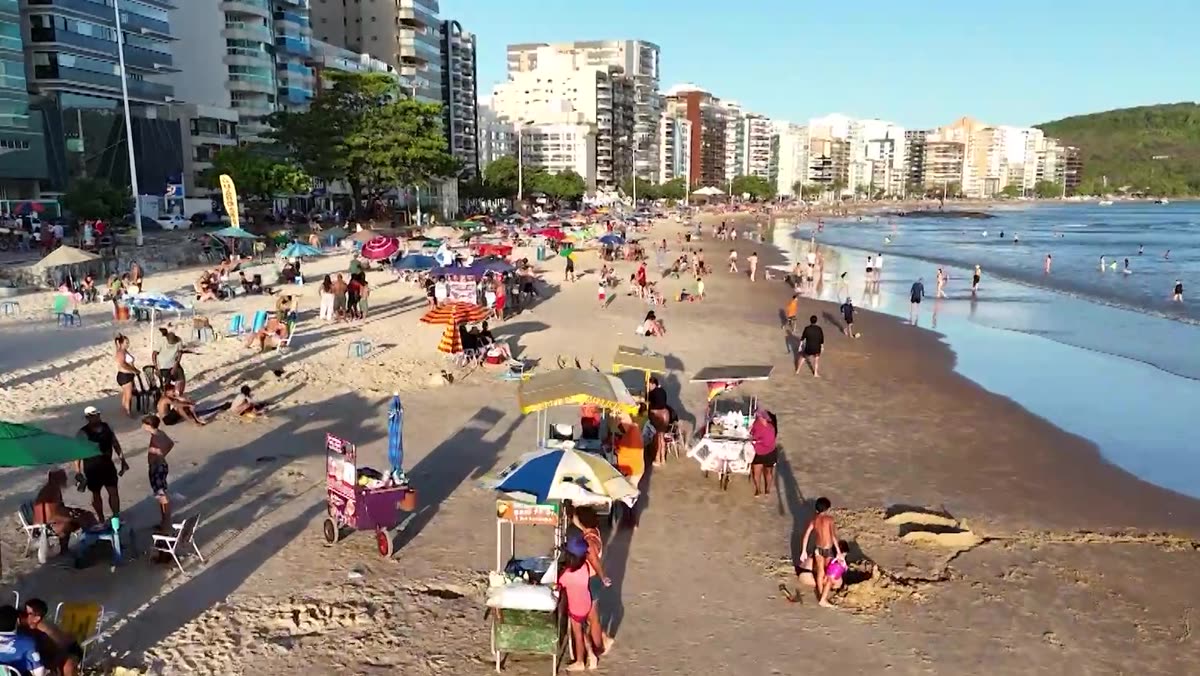 Praia e orla de Guarapari com movimento de pessoas