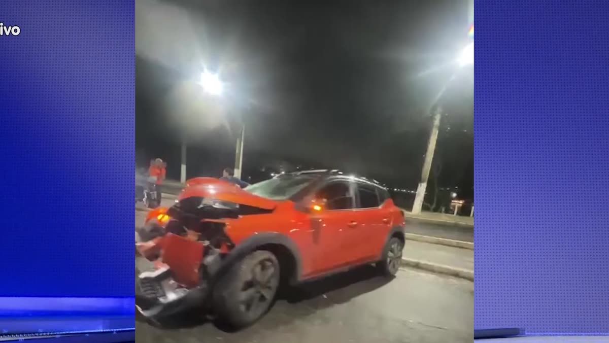 Carro laranja com a frente danificada após a colisão