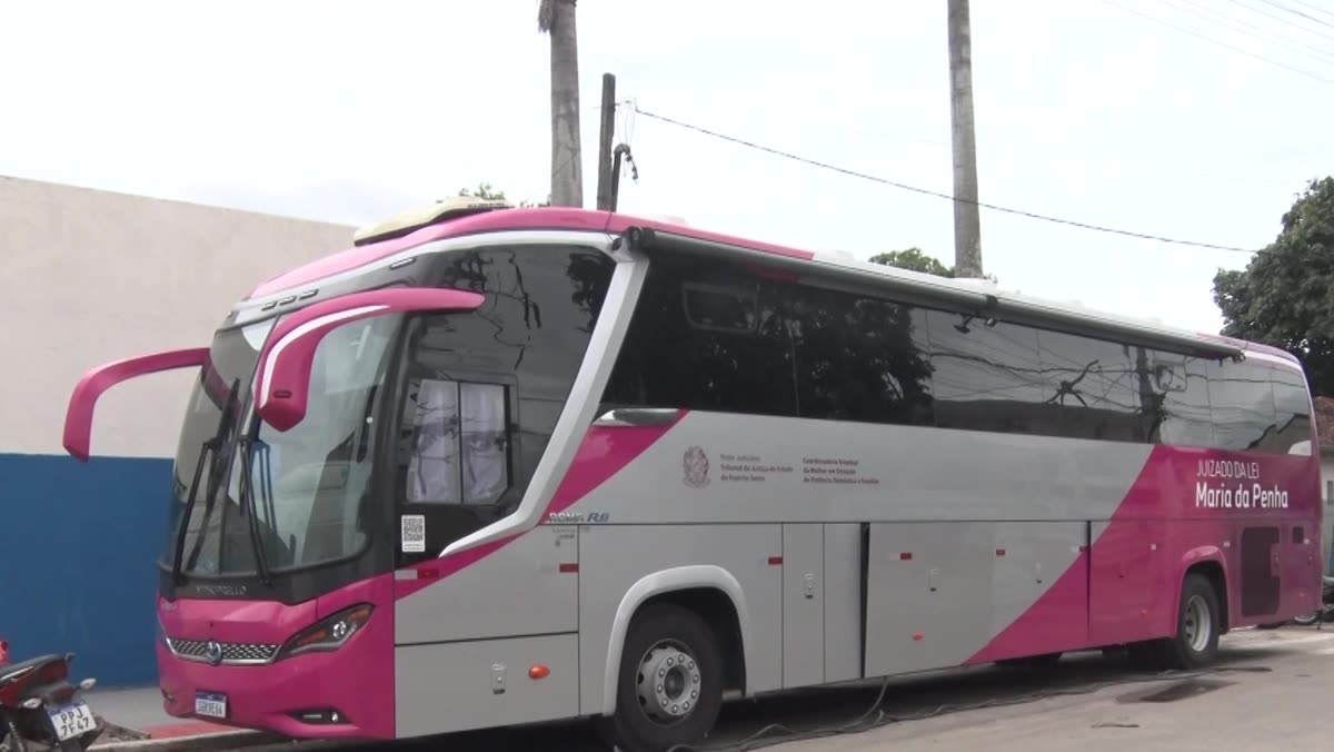 Ônibus rosa do Tribunal de Justiça estacionado em frente à escola