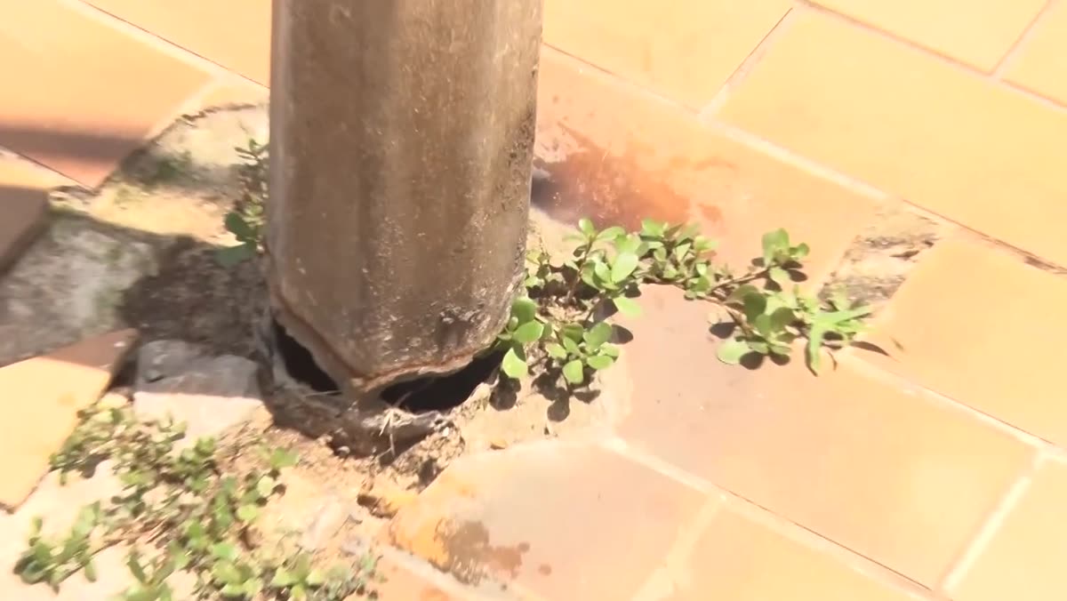 Placa de identificação no calçadão da Praia das Virtudes, em Guarapari, com a base danificada