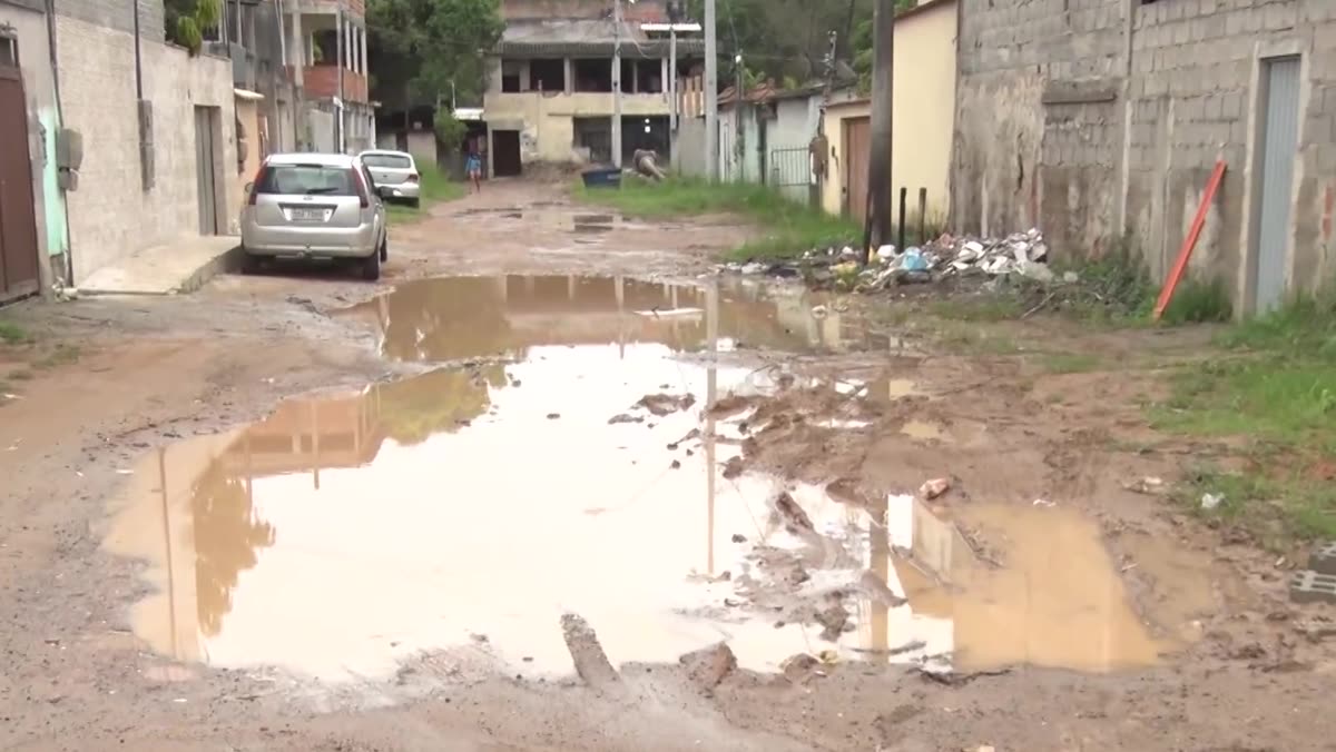 Rua de terra com lama, buracos e lixo acumulado