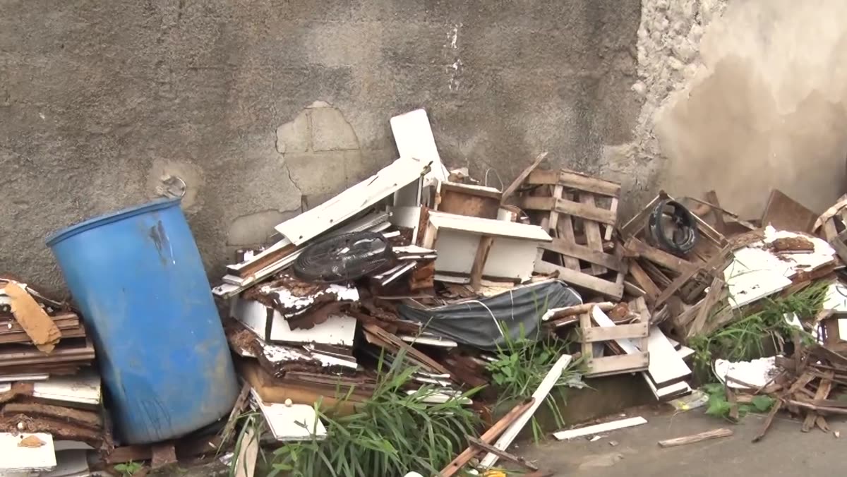 Móveis quebrados, madeira e lixo acumulados na calçada da Avenida Pernambuco