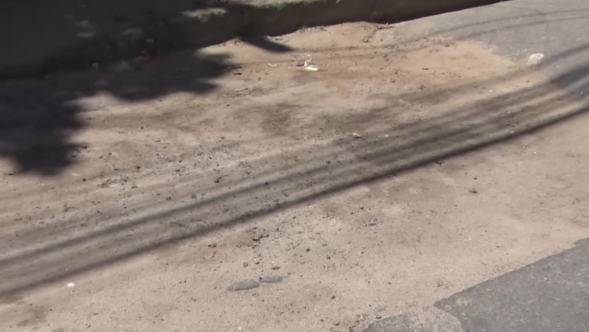 Buraco aterrado com terra no asfalto da Rua Bom Retiro, no Elza Nader
