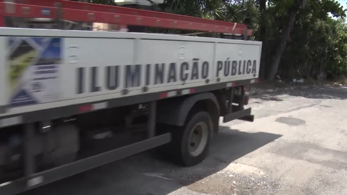Carros passando por rua de mão dupla ao lado do buraco