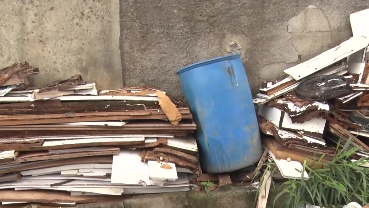 Balde de lixo ao lado de sacos e restos de lixo espalhados na rua
