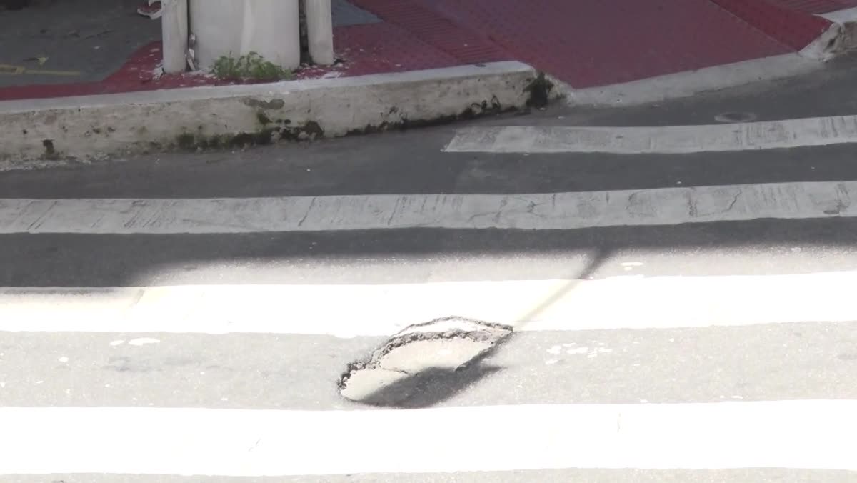 Buraco no asfalto sobre a faixa de pedestres