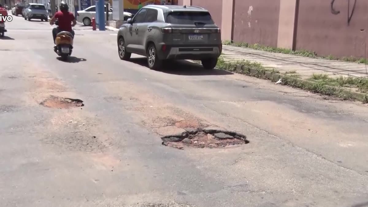 Buracos no asfalto da Rua Cannes, com carros passando