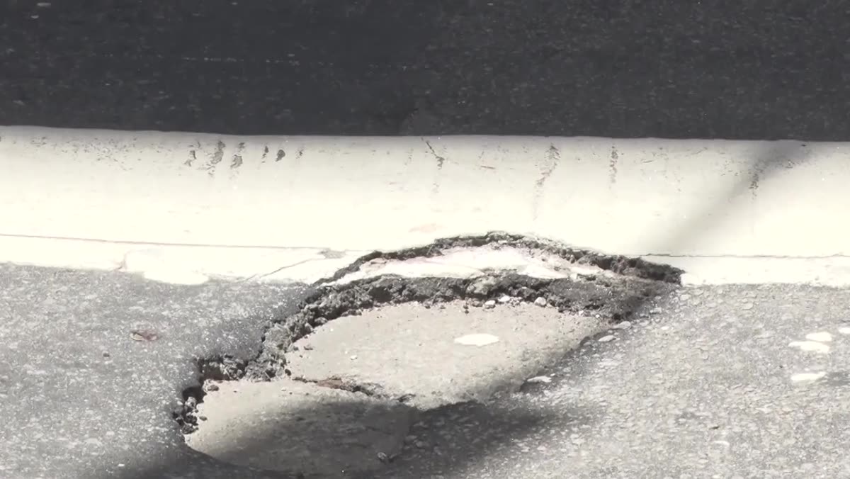 Carro passando sobre o trecho danificado da faixa de pedestres