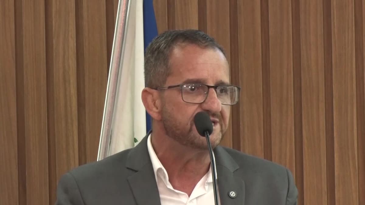 Vereador falando ao microfone no plenário